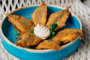 Frittino di sarde croccanti con maionese all'erba cipollina in una ciotola azzurra
