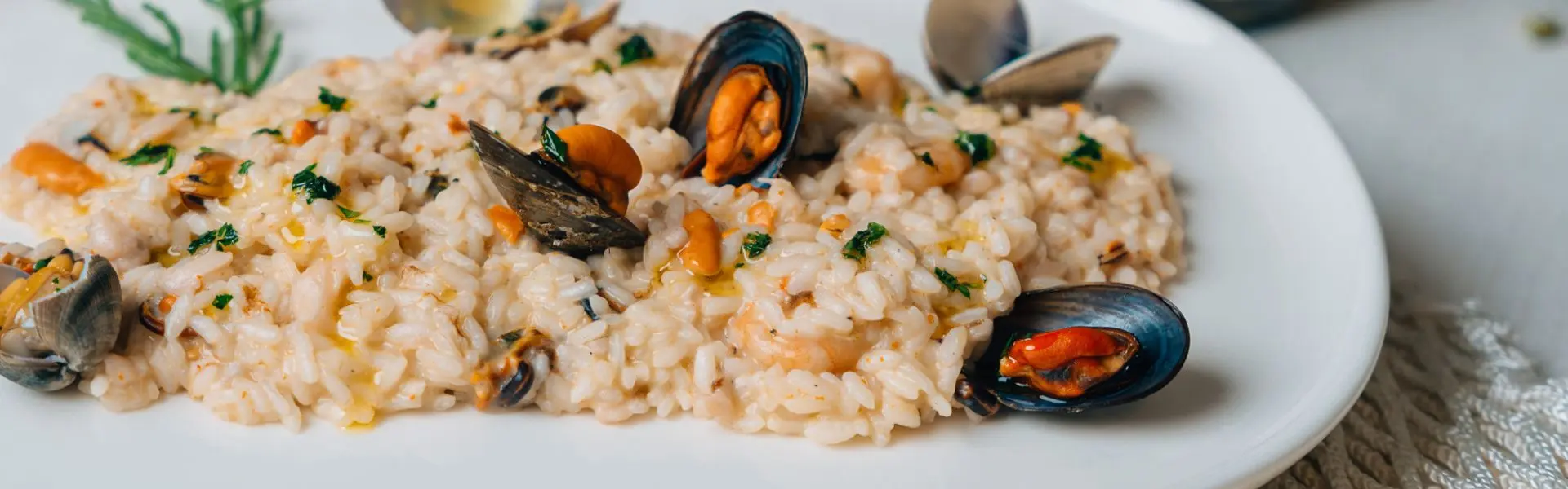 Risotto with mussels and seafood served on a white plate